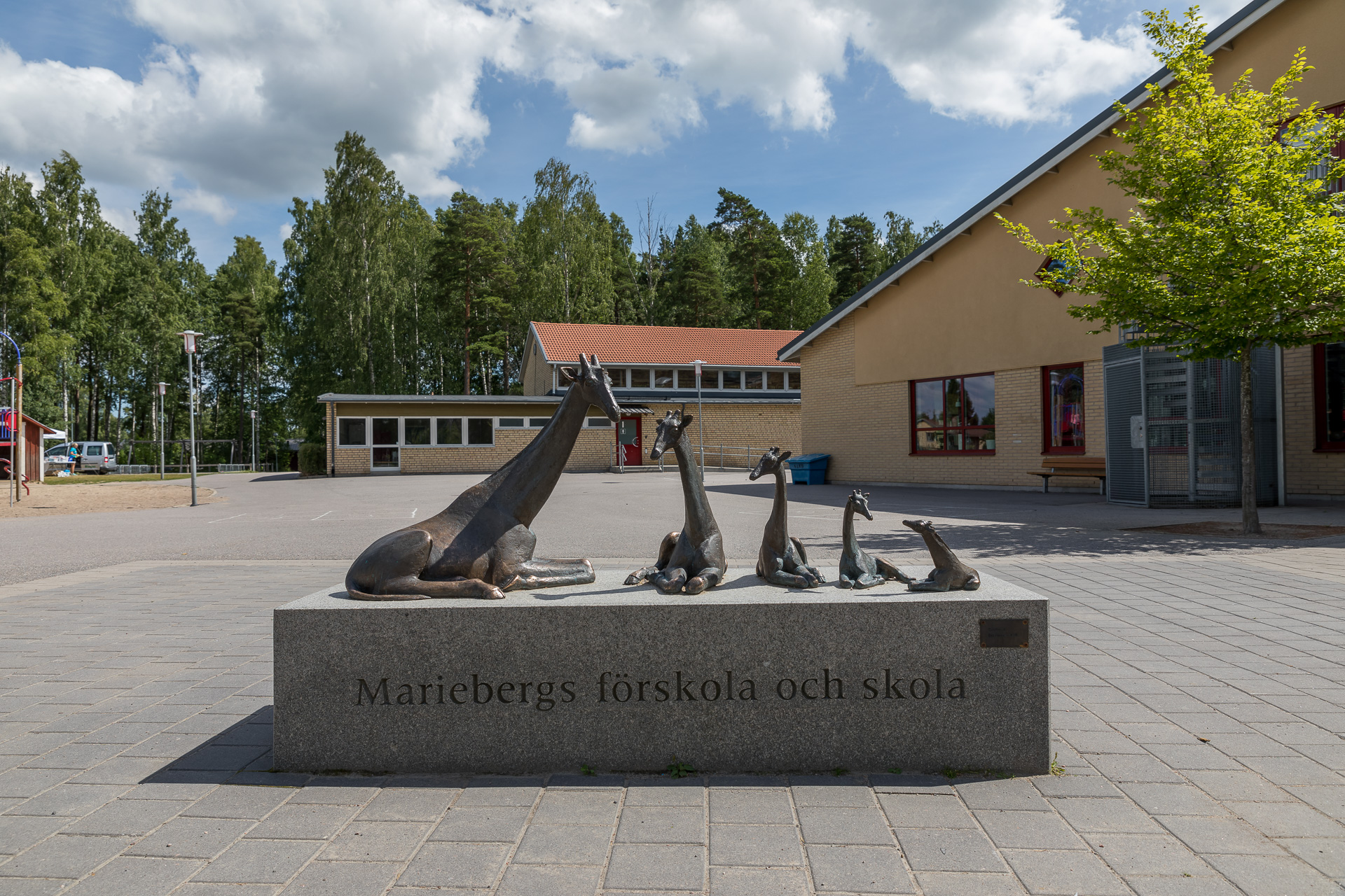 Fem djur på stenblock med texten "Mariebergs förskola och skola".