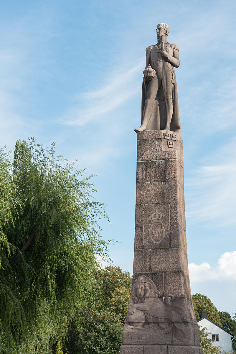 Staty i granit på ett fundament som är flera meter högt.