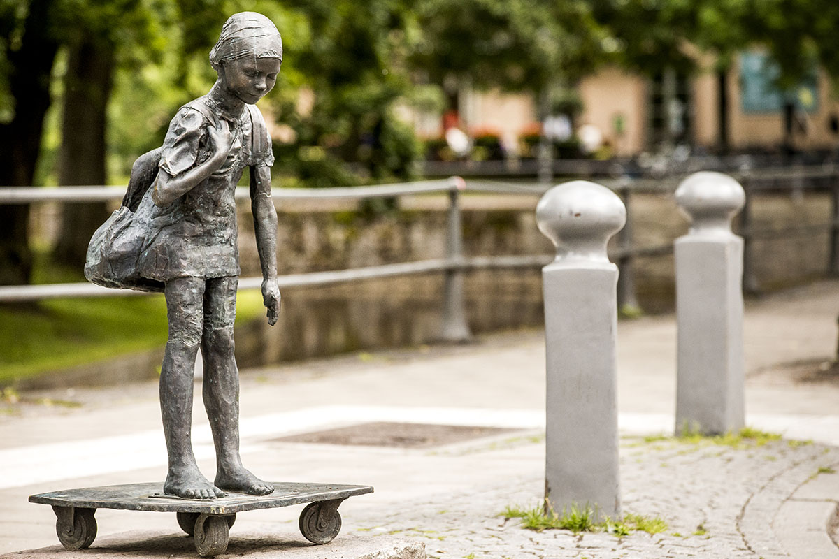 Statue with girl standing on square skateboard.