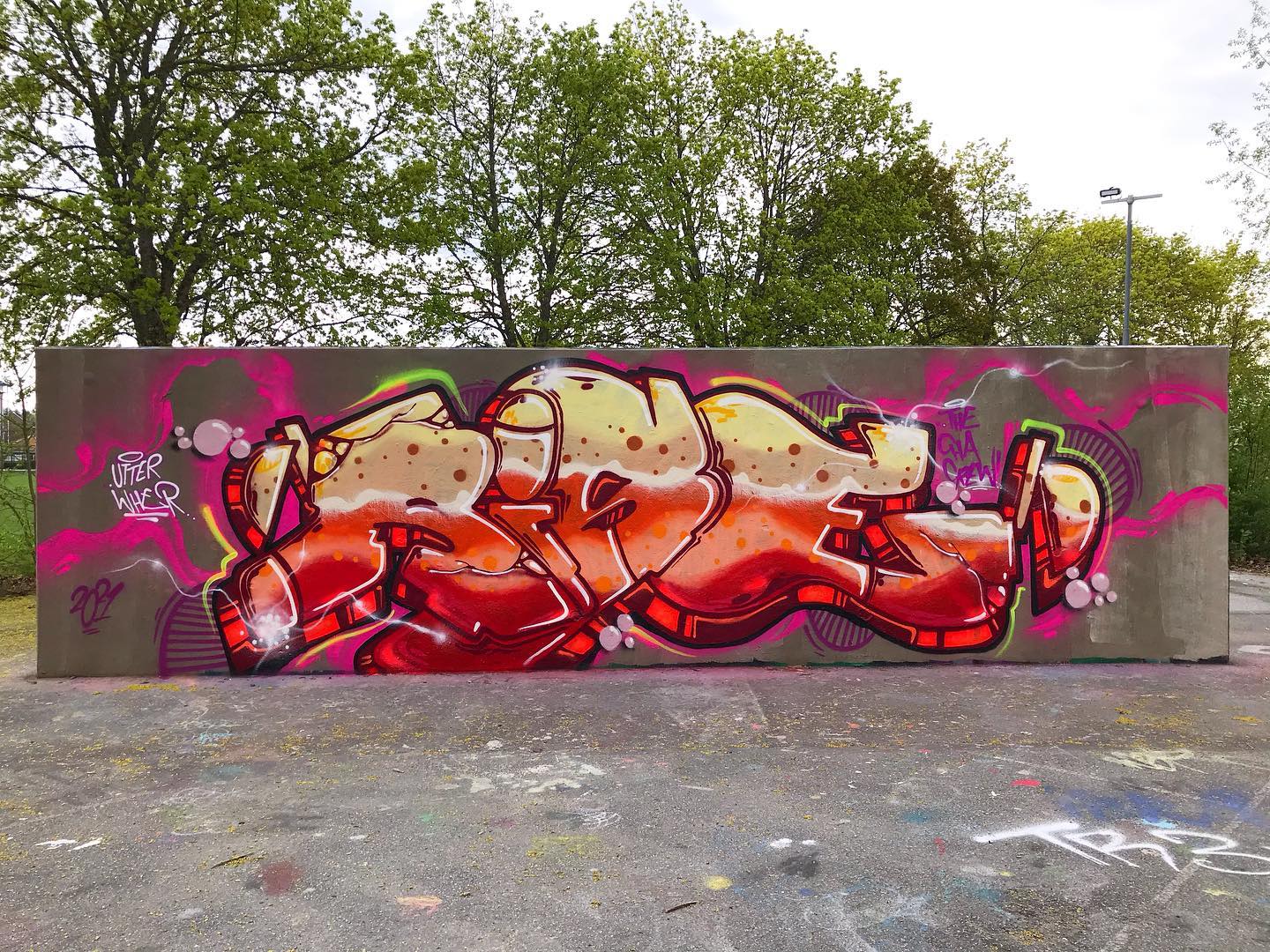 Rödgul, abstrakt graffittimålning på betongvägg.